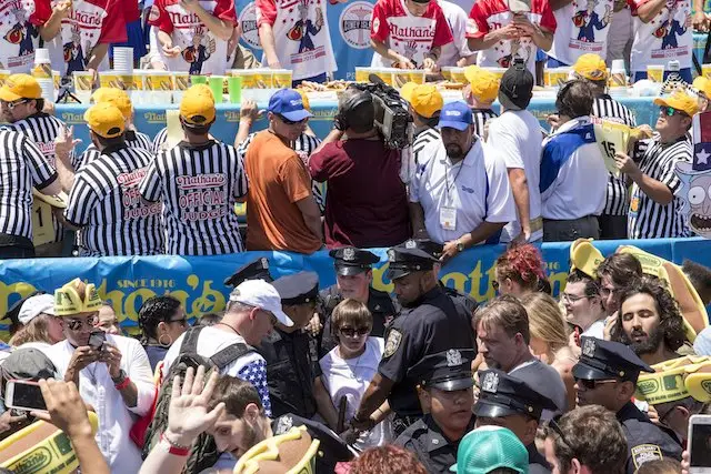 Police arrest an animal rights protester at the Nathan's Hot Dog Eating Contest on July 4th.